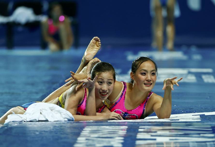 Atlete nordcoreane di nuoto sincronizzato posano per la stampa dopo la gara (Reuters)